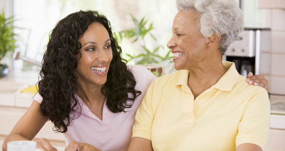 caregiver and elder woman smiling looking each other